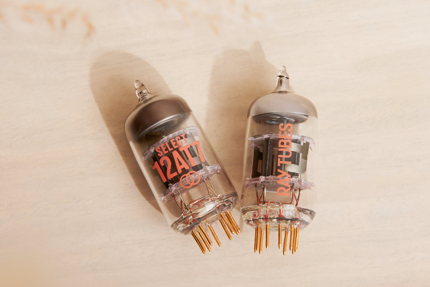 Two vacuum tubes with visible branding on a beige background