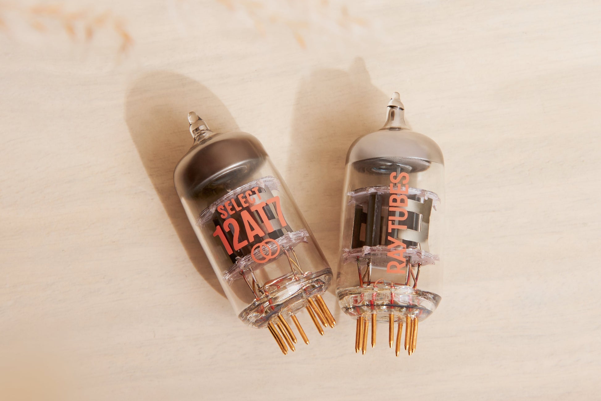 Two vacuum tubes with visible branding on a beige background