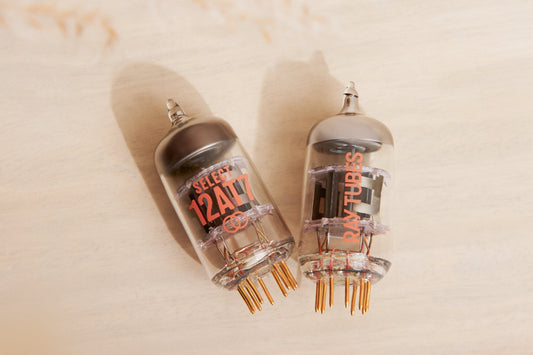 Two vacuum tubes with visible branding on a beige background