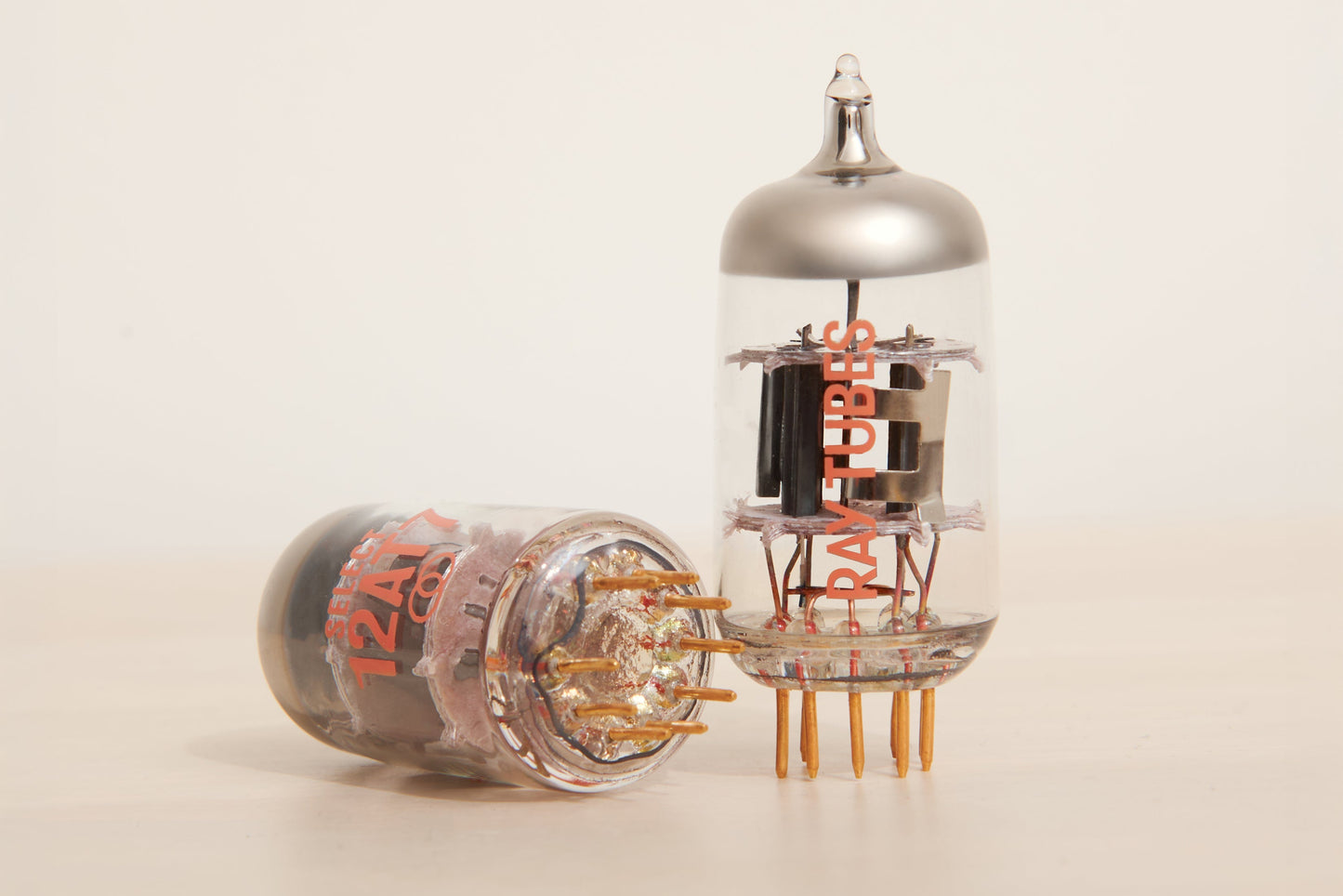 Two vacuum tubes with visible branding on a beige background