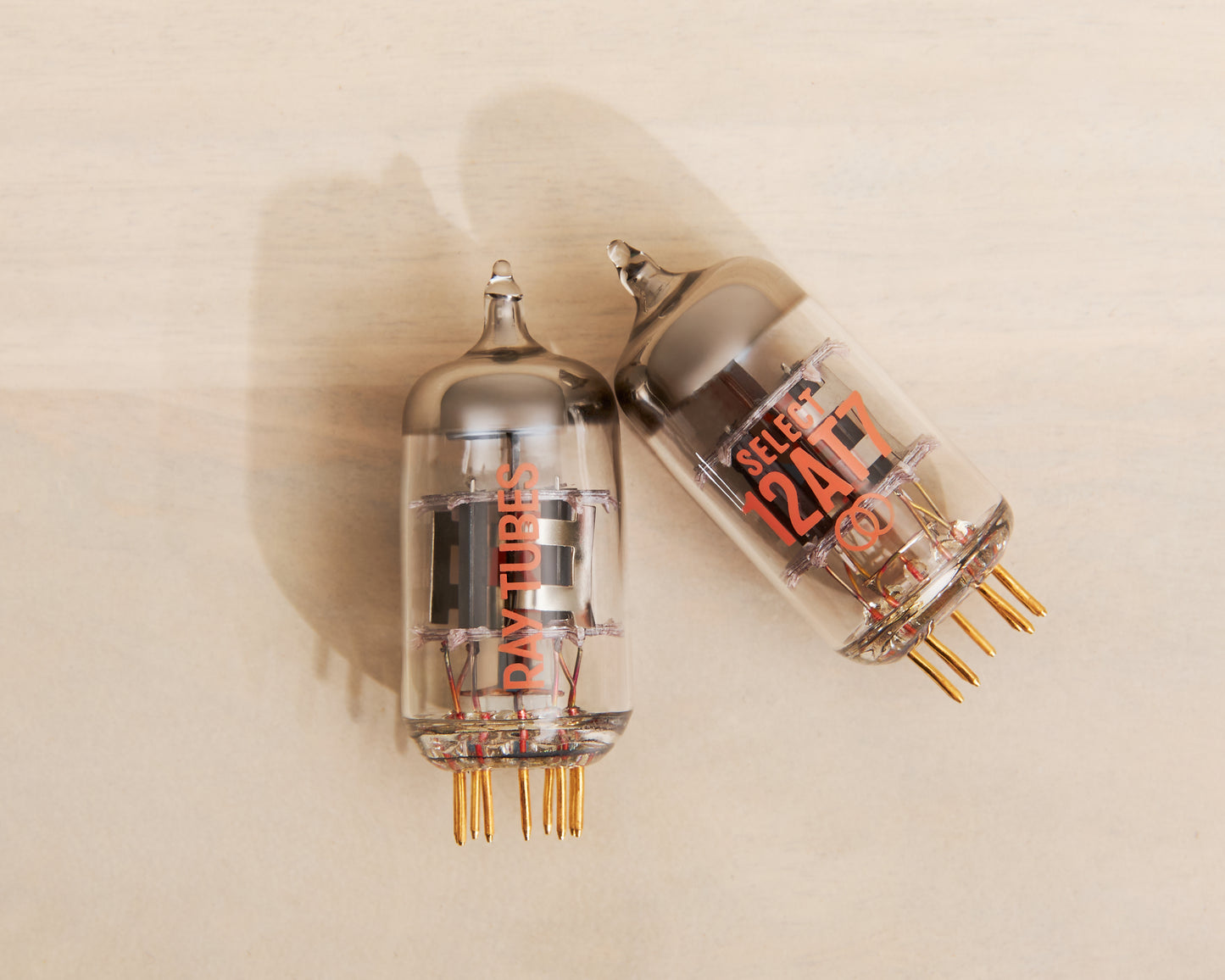 Two vacuum tubes with visible branding on a beige background
