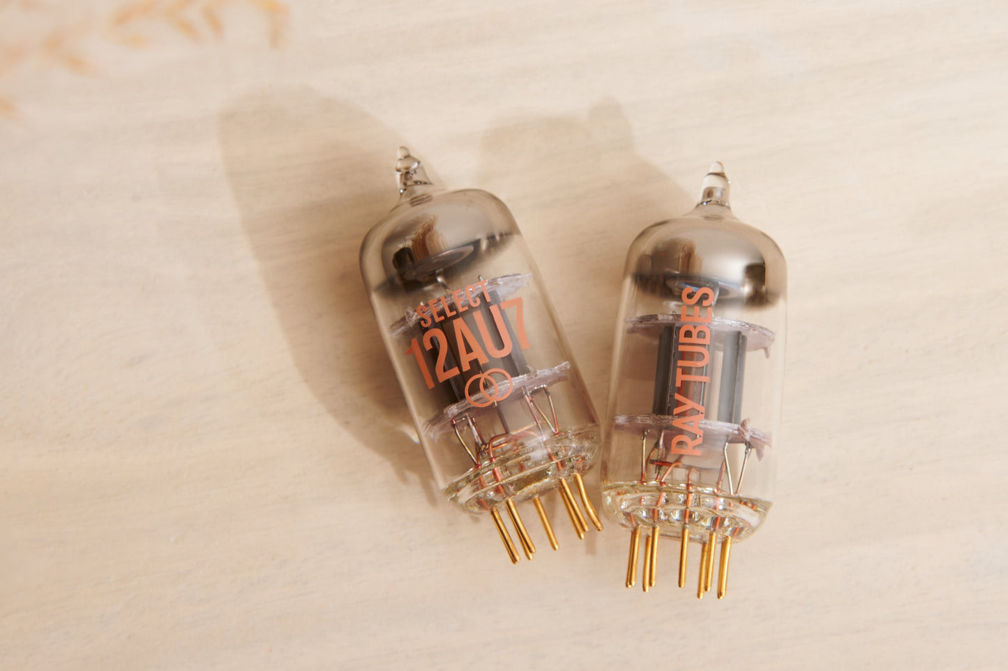 Two vacuum tubes with 'Ray Tubes' branding on a beige background