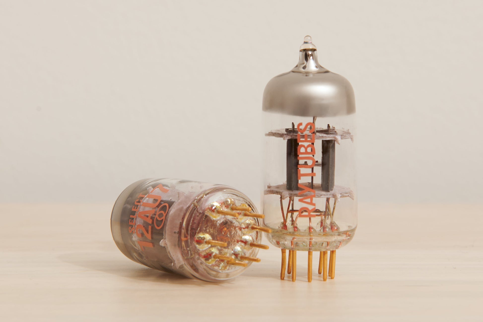 Two vacuum tubes on a beige background