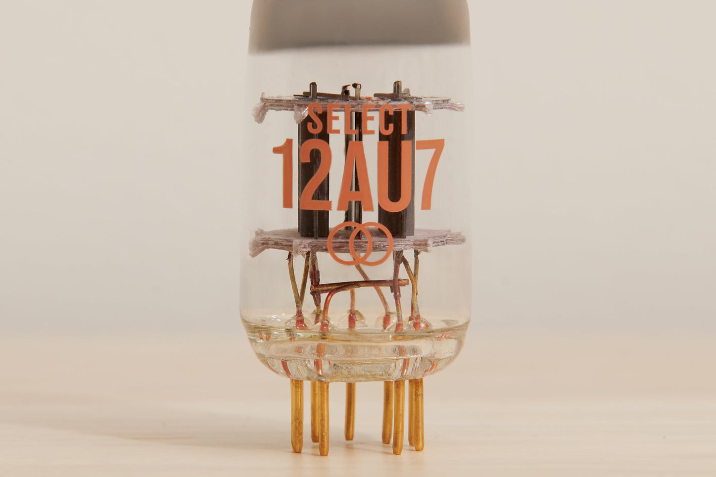 Vacuum tube with 'SELECT 12AU7' text on a beige background