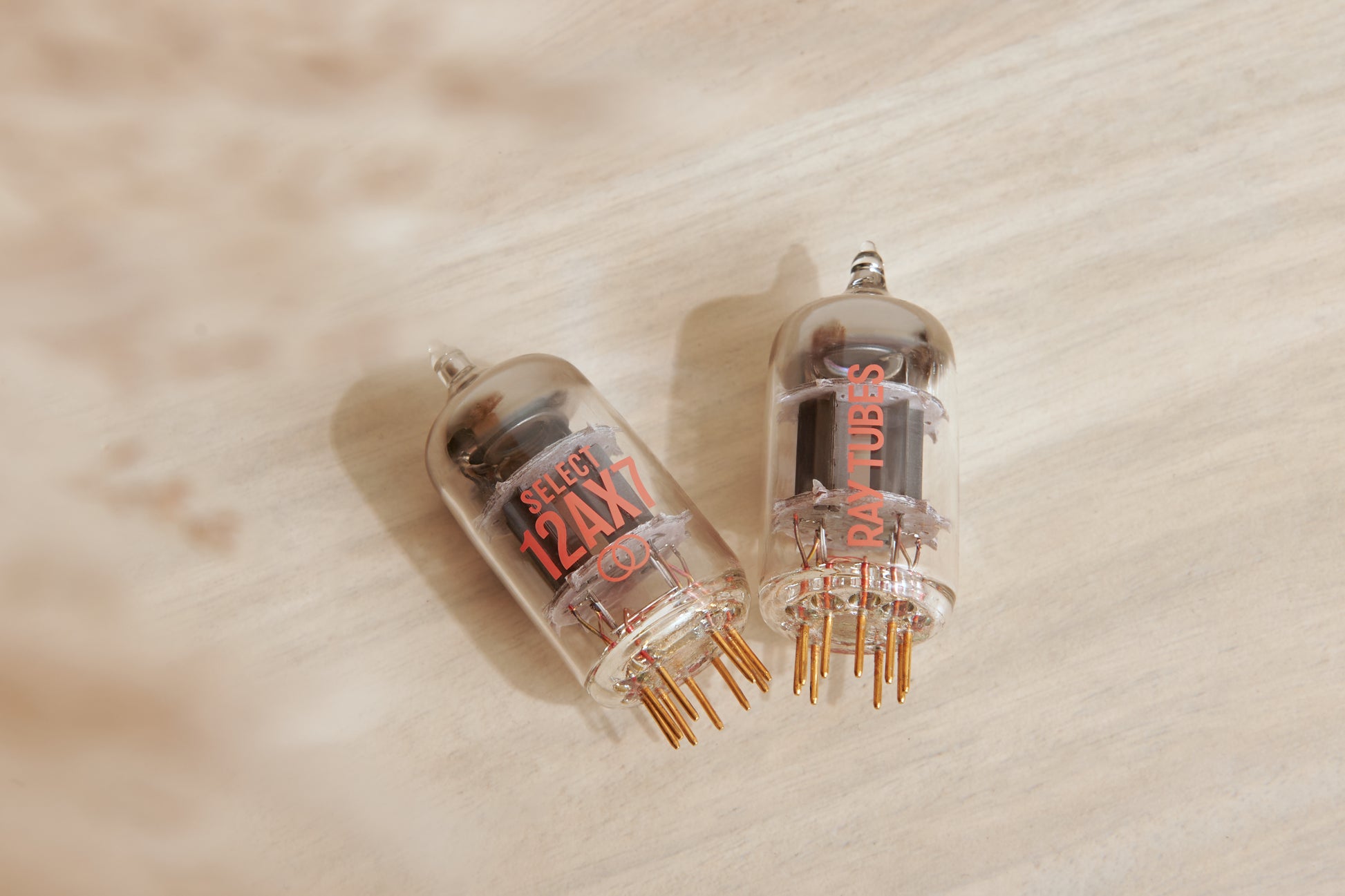 Two vacuum tubes on a wooden surface
