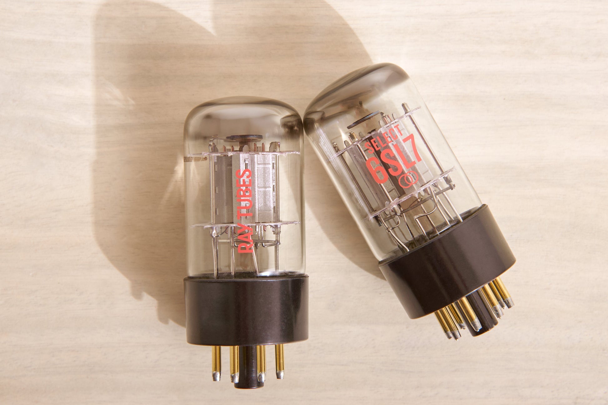 Two vacuum tubes on a beige background