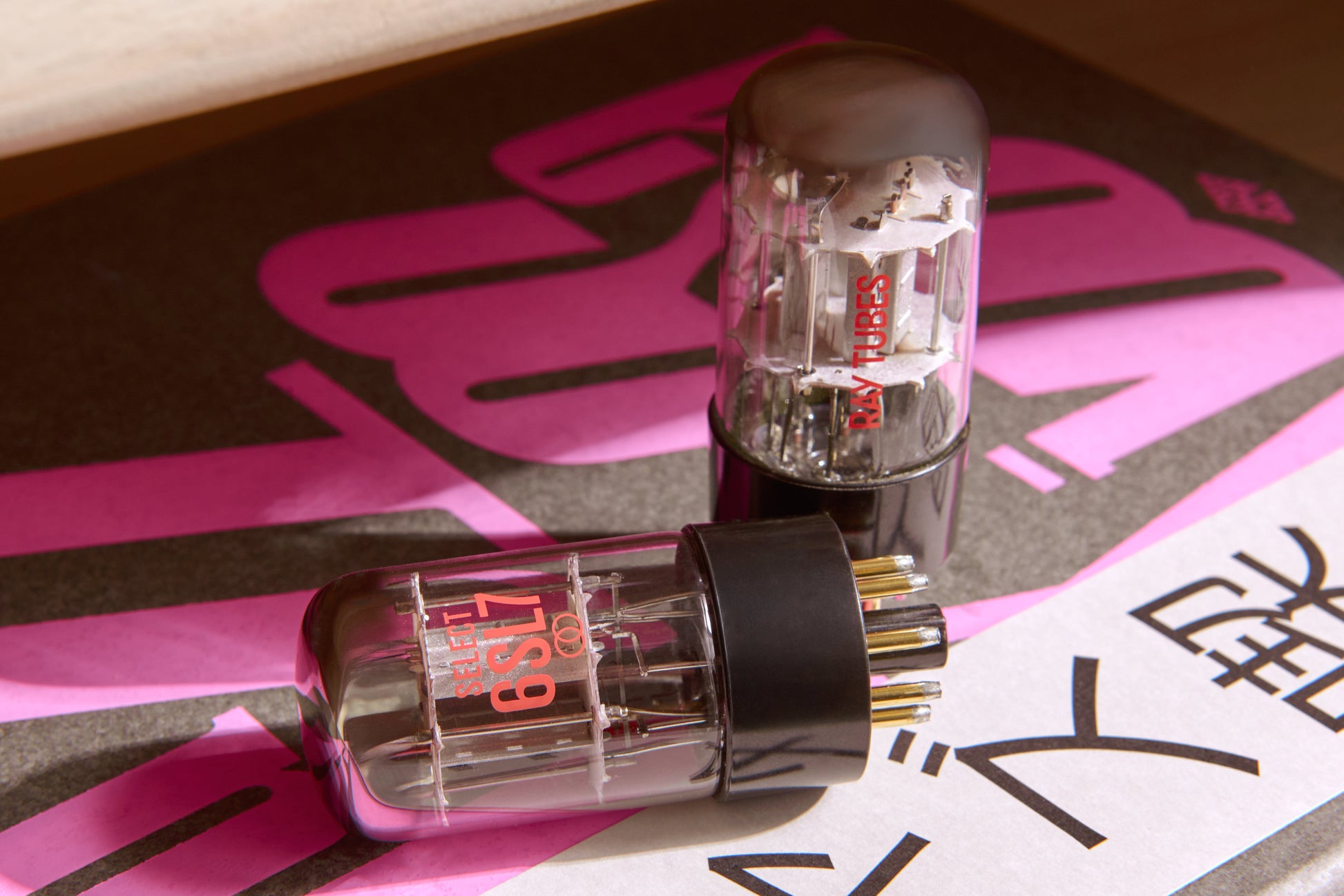 Two vacuum tubes with 'SELECT 6SL7' marking on a reflective surface.