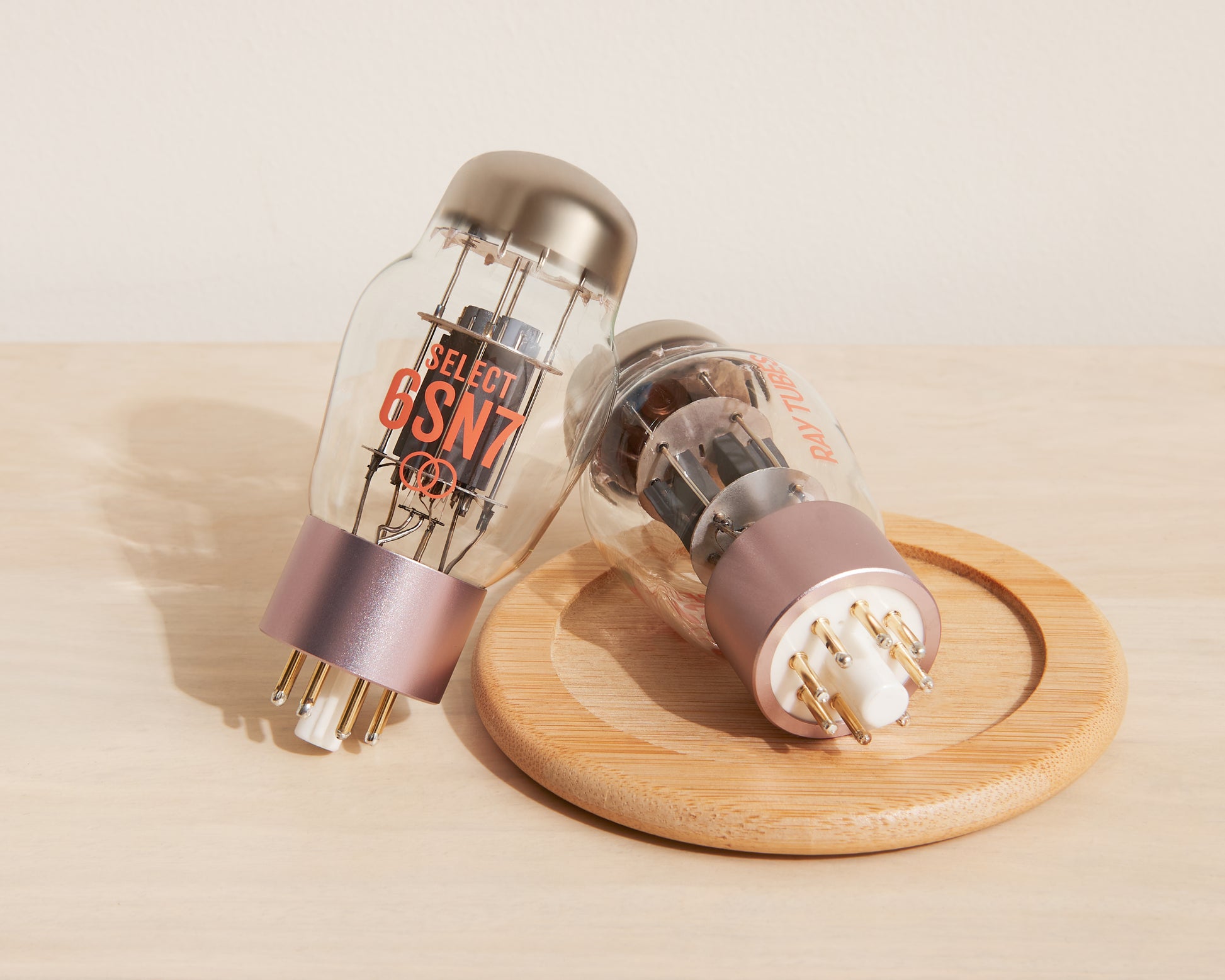 Two vacuum tubes on a wooden coaster with a beige background