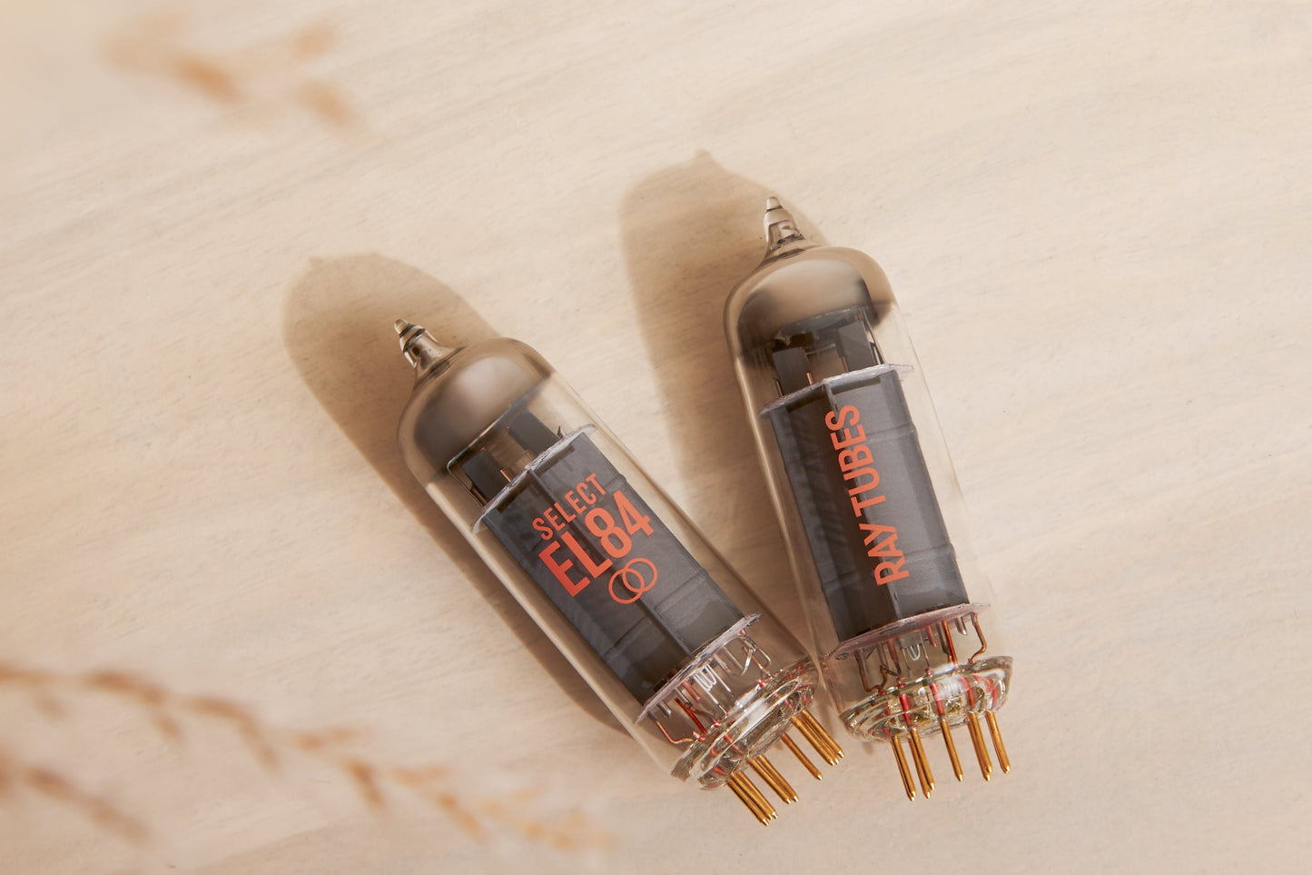 Two vacuum tubes with 'SELECT EL84' and 'Ray Tubes' markings on a beige background