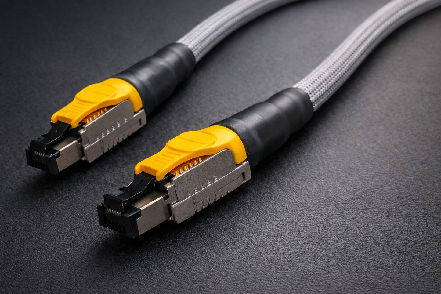 a close-up view of a black and gray cable with yellow connectors, likely used for data transmission or networking purposes.